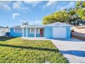 Charming home with a welcoming front porch, well-manicured lawn, and an attached garage, creating great curb appeal at 3814 Sunray Dr, Holiday, FL 34691