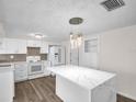 Renovated kitchen with new appliances, a white island, and sleek design, creating a modern and functional space at 3814 Sunray Dr, Holiday, FL 34691