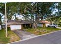 Street view of a brick home with a two-car garage and well-maintained lawn, shaded by a mature tree at 3960 13Th Ne Way, St Petersburg, FL 33703