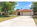 Front view of home featuring two-car garage, a well-maintained lawn and front entrance at 5140 Kirkwood Ave, Spring Hill, FL 34608