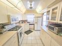 Bright kitchen featuring tile floors, white appliances, generous cabinet space, and eat-in potential at 6020 Shore S Blvd # 902, Gulfport, FL 33707