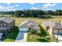 Aerial view of a single-story home, landscaped yard, and green neighborhood with nearby park and other single-story homes at 6727 Bar S Bar Trail, Zephyrhills, FL 33541