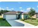 Charming single-story home with a two-car garage, well-maintained lawn, and inviting curb appeal under a bright sky at 6727 Bar S Bar Trail, Zephyrhills, FL 33541