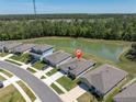 Aerial view of a home backing onto a pond, surrounded by lush greenery in a serene neighborhood at 8352 Greenway Ave, Wesley Chapel, FL 33544
