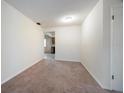 Carpeted living room with neutral walls leads to kitchen in this quaint property at 8445 Calais N, Pinellas Park, FL 33781
