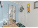 Bright foyer entrance featuring mirrored closet doors, updated flooring, and a decorative wreath at 12760 Indian Rocks Rd # 571, Largo, FL 33774