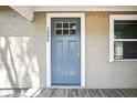 Close-up of the front door featuring a light blue door with a white frame and the house number 1000 at 1000 8Th Sw Ave, Largo, FL 33770