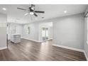 Open living room featuring wood-look floors, a ceiling fan, and sliding glass doors to the backyard at 1000 8Th Sw Ave, Largo, FL 33770
