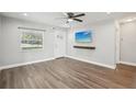 Bright living room with a ceiling fan, wood-look floors, mounted TV, and plenty of natural light at 1000 8Th Sw Ave, Largo, FL 33770