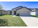 Charming single-story home with a well-maintained lawn, a two-car garage and neutral color palette at 1001 Culbreath Green Ct, Ruskin, FL 33570