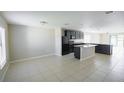 Open-concept kitchen and dining area with sleek, dark cabinets, granite countertops, and tile flooring at 1001 Culbreath Green Ct, Ruskin, FL 33570