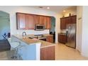 A kitchen featuring wood cabinets, granite countertops, and stainless steel appliances, perfect for cooking at 10048 Cleghorn Dr, San Antonio, FL 33576