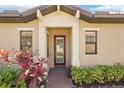 Inviting front entrance with a glass-paneled door, red pavers, and lush landscaping at 10612 Glencorse Ter, Bradenton, FL 34211