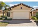 A tan home with a large two car garage and brick paver driveway at 10612 Glencorse Ter, Bradenton, FL 34211