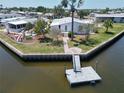 Waterfront property featuring a private dock and a meticulously maintained lawn with garden at 131 E Saint Annes Cir, Apollo Beach, FL 33572
