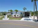 Charming single-story home with a covered carport, palm trees, and well-maintained landscaping at 131 E Saint Annes Cir, Apollo Beach, FL 33572