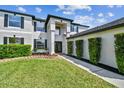 Stunning two-story home featuring manicured landscaping and a modern architectural design with clean lines and dark trim at 16323 Muirfield Dr, Odessa, FL 33556