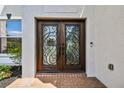 Close-up of an elegant double front door with decorative ironwork and a brick entrance at 16323 Muirfield Dr, Odessa, FL 33556