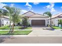 Charming single-story home featuring a tile roof, a two-car garage, and beautifully maintained landscaping at 17214 Star Banks St, Wimauma, FL 33598