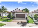 Charming single-story home featuring a tile roof, a two-car garage, and beautifully maintained landscaping at 17214 Star Banks St, Wimauma, FL 33598