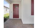 Inviting front entrance with a brick-paved porch and a stylish, modern door with glass pane at 17214 Star Banks St, Wimauma, FL 33598