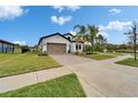 Lovely single-Gathering home with a manicured lawn, mature landscaping, and a paved driveway leading to a two-car garage at 19611 Cypress Bridge Dr, Odessa, FL 33556