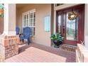 Cozy front porch with comfortable blue chairs, a decorative wreath, and charming decor at 22932 Collridge Dr, Land O Lakes, FL 34639