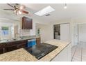 Bright kitchen with granite countertops, stainless sink, and modern appliances under a skylight at 230 Davison Ne Ave, St Petersburg, FL 33703