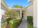 Charming home entrance with manicured shrubbery, a walkway, and a well-lit doorway at 2618 Newcomb Ct # 12, Sun City Center, FL 33573