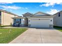 Inviting single-story house with a two-car garage, stone details, and a well-kept lawn at 2934 Living Coral Dr, Odessa, FL 33556