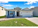 Attractive house with stone accents, a two-car garage, and a welcoming front yard at 2934 Living Coral Dr, Odessa, FL 33556