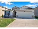 Beautifully landscaped home featuring a two-car garage, stone accents, and manicured lawn at 2934 Living Coral Dr, Odessa, FL 33556