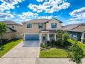 Beautiful two-story home with a well-manicured lawn, blue accents, and inviting front porch with rocking chairs at 32101 Goddard Dr, Wesley Chapel, FL 33543