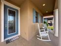 Inviting front porch with rocking chairs, blue door, and well-maintained landscaping creating a welcoming entrance at 32101 Goddard Dr, Wesley Chapel, FL 33543