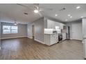 Modern open-concept kitchen with white cabinets, stainless steel appliances, and wood-look flooring at 3451 Pine St, Dunedin, FL 34698