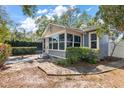 Quaint home exterior featuring a side patio area, lush landscaping, and manicured lawn at 3726 Prescott N St, St Petersburg, FL 33713