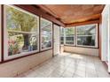Bright sunroom featuring large windows, tiled floors, and a decorative wood ceiling at 3726 Prescott N St, St Petersburg, FL 33713