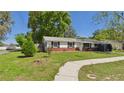 Traditional single-story home showing mature trees and shrubs in a well-maintained front yard at 39233 9Th Ave, Zephyrhills, FL 33542
