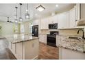 Modern kitchen features white cabinets, granite countertops, and stainless-steel appliances at 4205 57Th N Ave, St Petersburg, FL 33714