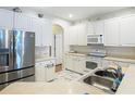 Bright kitchen featuring white cabinetry, stainless steel refrigerator, and updated countertops at 4262 Larkenheath Dr, Spring Hill, FL 34609