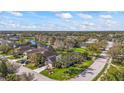 Aerial view of a suburban neighborhood with single-Gathering homes and landscaped lawns near a pond at 4811 Forest Creek Trl, Parrish, FL 34219