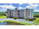Low aerial view of a seven-story condo building with verdant landscaping and waterfront views at 6495 Shoreline Dr # 8105, Seminole, FL 33708