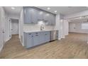 Open-concept kitchen featuring gray cabinets, stainless appliances, and wood-look flooring at 6672 56Th N Ave, St Petersburg, FL 33709
