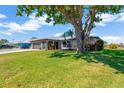 Charming single-story home featuring a two-car garage, stone accents, and mature landscaping on a well-maintained lawn at 7094 Kenwood Dr, North Port, FL 34287