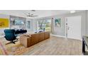 Bright living room with modern furniture, wood flooring, and a large window at 7094 Kenwood Dr, North Port, FL 34287