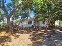 Single-story home shaded by large, mature trees, creating a private and inviting atmosphere at 714 Gray S St, Gulfport, FL 33707