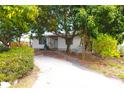 Modest single-story home with a spacious driveway and mature trees, exuding suburban charm at 714 Gray S St, Gulfport, FL 33707
