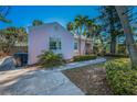 Side exterior showcasing the home's architecture, landscape and walkway on a sunny day at 805 Bruce Ave, Clearwater Beach, FL 33767
