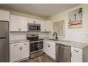 Modern kitchen features stainless steel appliances, white cabinetry, and tiled backsplash at 8423 Jackson Springs Rd, Tampa, FL 33615