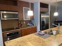 Modern kitchen with stainless steel appliances, granite countertops and wood cabinetry at 111 N 12Th St # 1426, Tampa, FL 33602